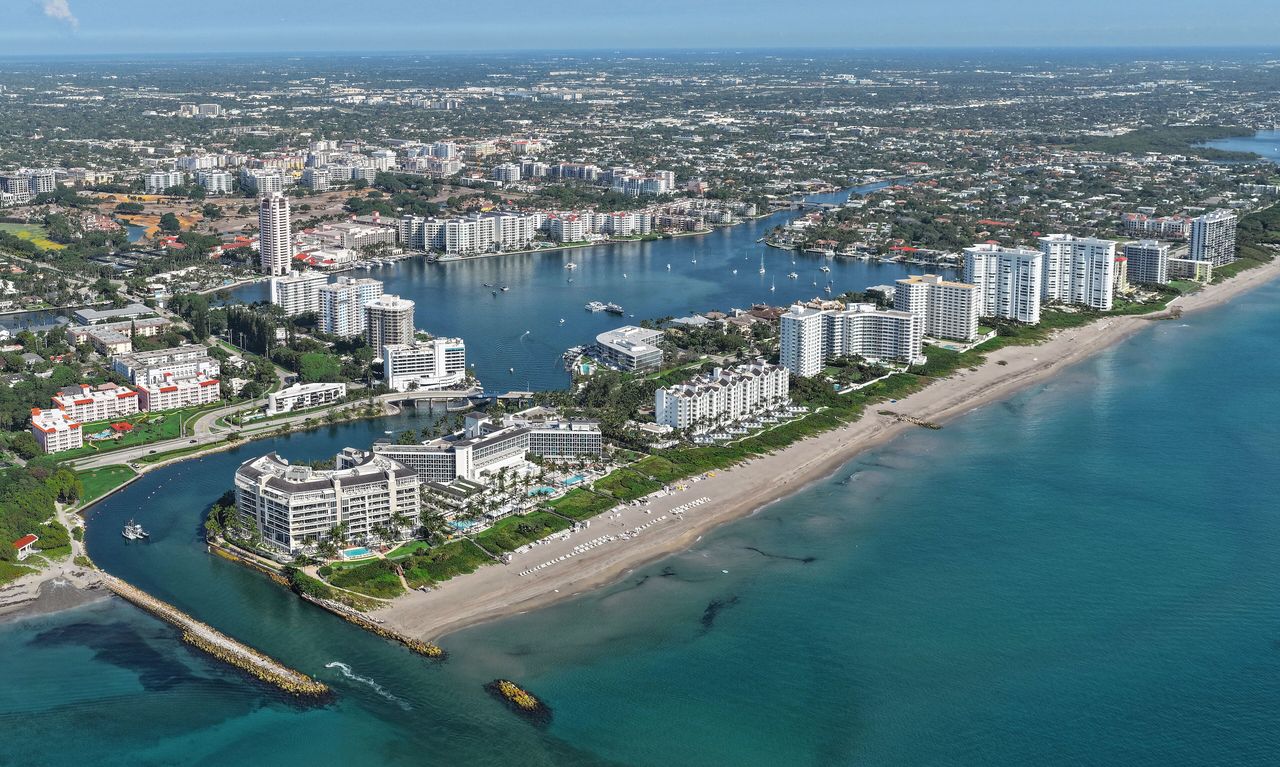 Aerial view of the Boca Raton Inlet and its jetties, a row of condo towers along the beach and Lake Boca Raton, with the low-rise city stretching inland