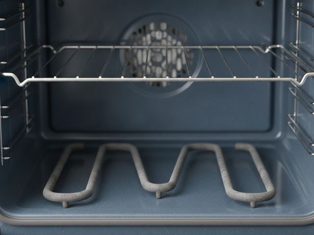 The bake element along the floor of an open electric oven, below a rack
