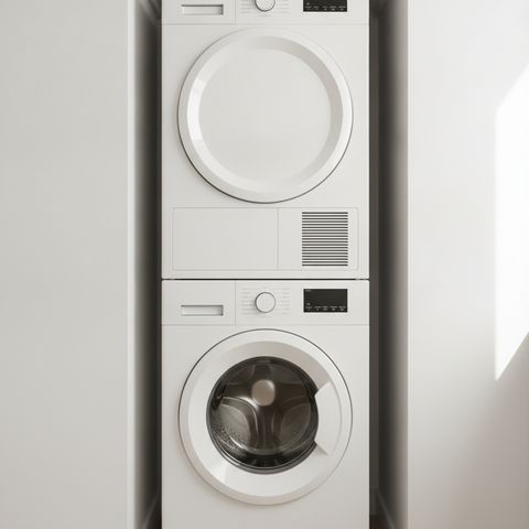 A white front-load washer with a matching dryer stacked on top of it in a laundry nook
