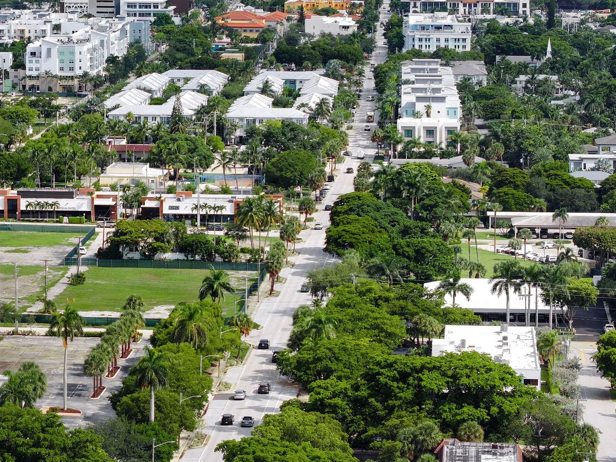 Delray Beach from above: rows of white townhouses, small houses under a thick tree canopy and a road running north