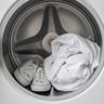 A pair of sneakers and a balled-up sheet inside a dryer drum