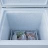 Frost coating the inside walls of an open chest freezer