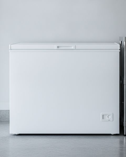 A white chest freezer with its lid closed against a wall