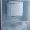 A refrigerator ice maker encased in ice, icicles hanging into the bin