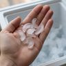 Small, thin crescent ice cubes in an open palm