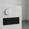 A washer’s control panel with a plain dial, three buttons and a blank display