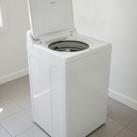 A white top-load washing machine with its lid raised