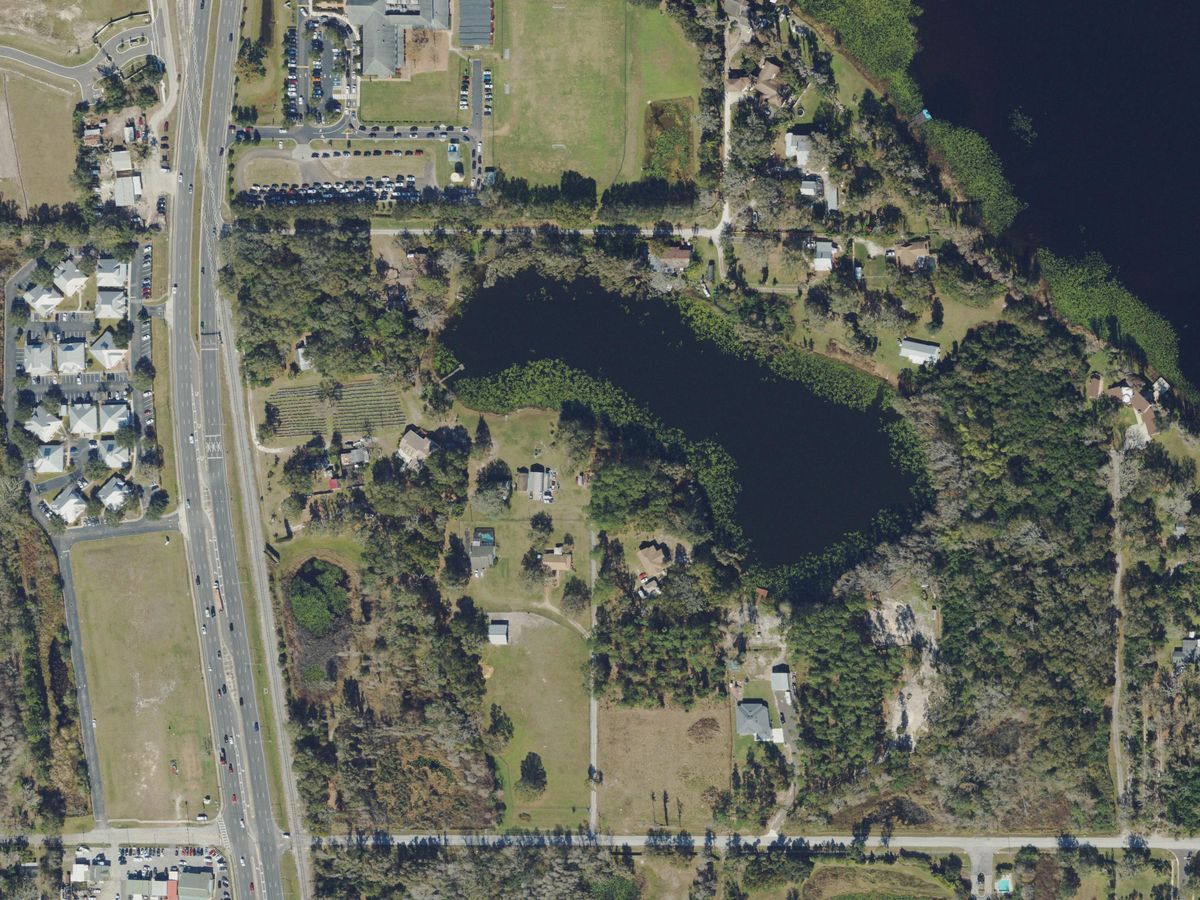 Lake Stemper beside US 41 in Lutz, with homes on large wooded lots, seen from above