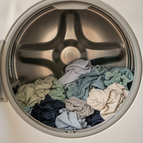 Damp clothes lying still at the bottom of an open dryer drum