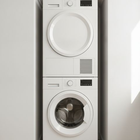 A white front-load washer with a matching dryer stacked on top of it in a laundry nook