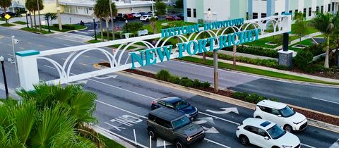 The Historic Downtown New Port Richey arch over a palm-lined street