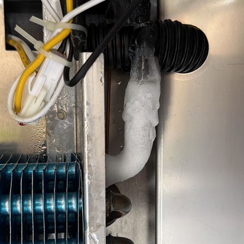 Tubing on a cooling coil iced over beside a bundle of wiring