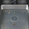 Cloudy water and a few food scraps standing in the bottom of a dishwasher tub