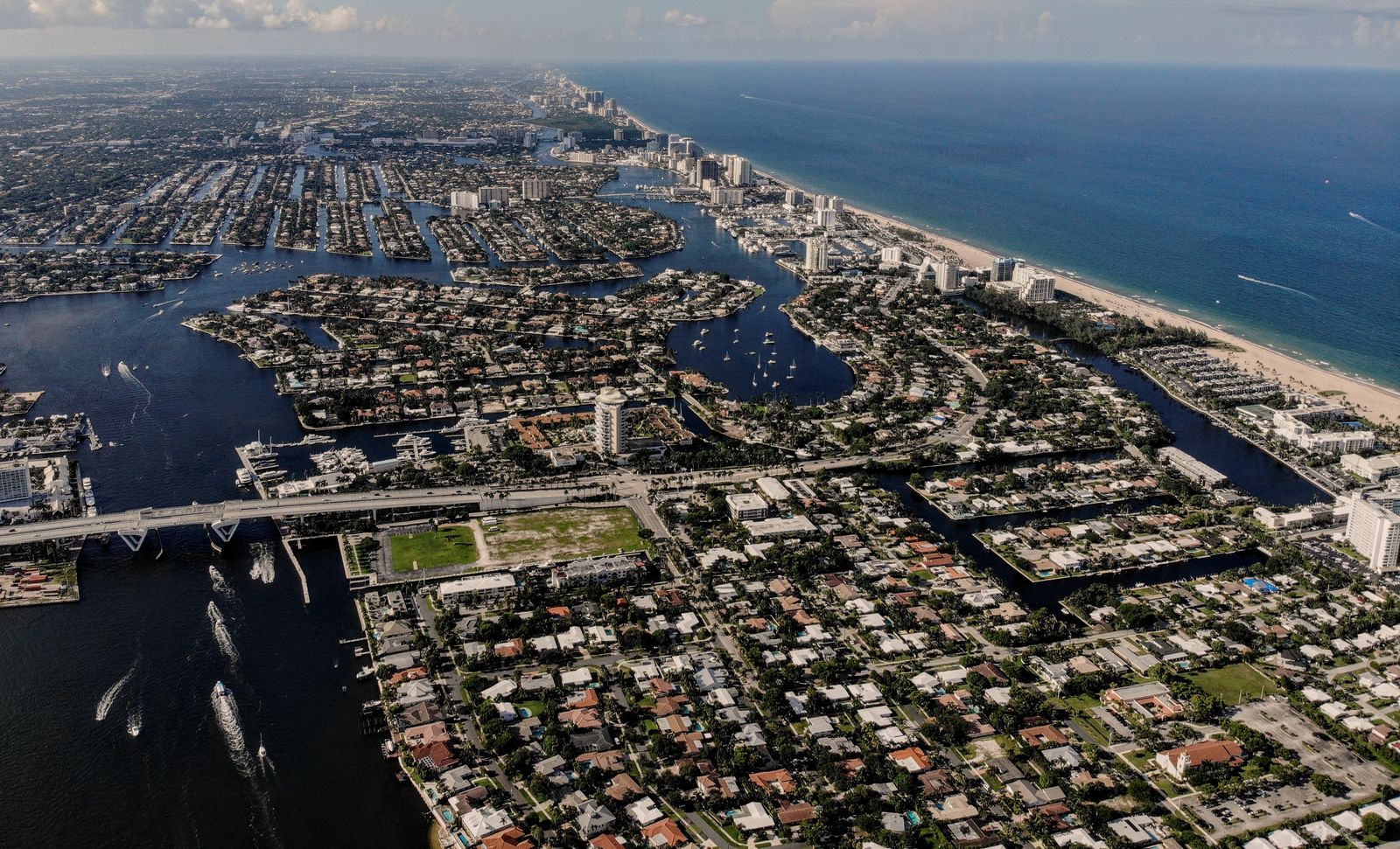 Fort Lauderdale from the air, looking north: tile-roofed streets and canals, boats on the Intracoastal Waterway, and towers along the beach