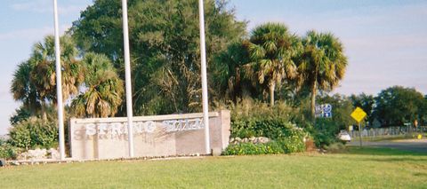 The Spring Hill entrance wall under palms and oaks