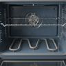 The bake element along the floor of an open electric oven, under a rack