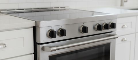 The black glass top and front control knobs of a stainless electric range