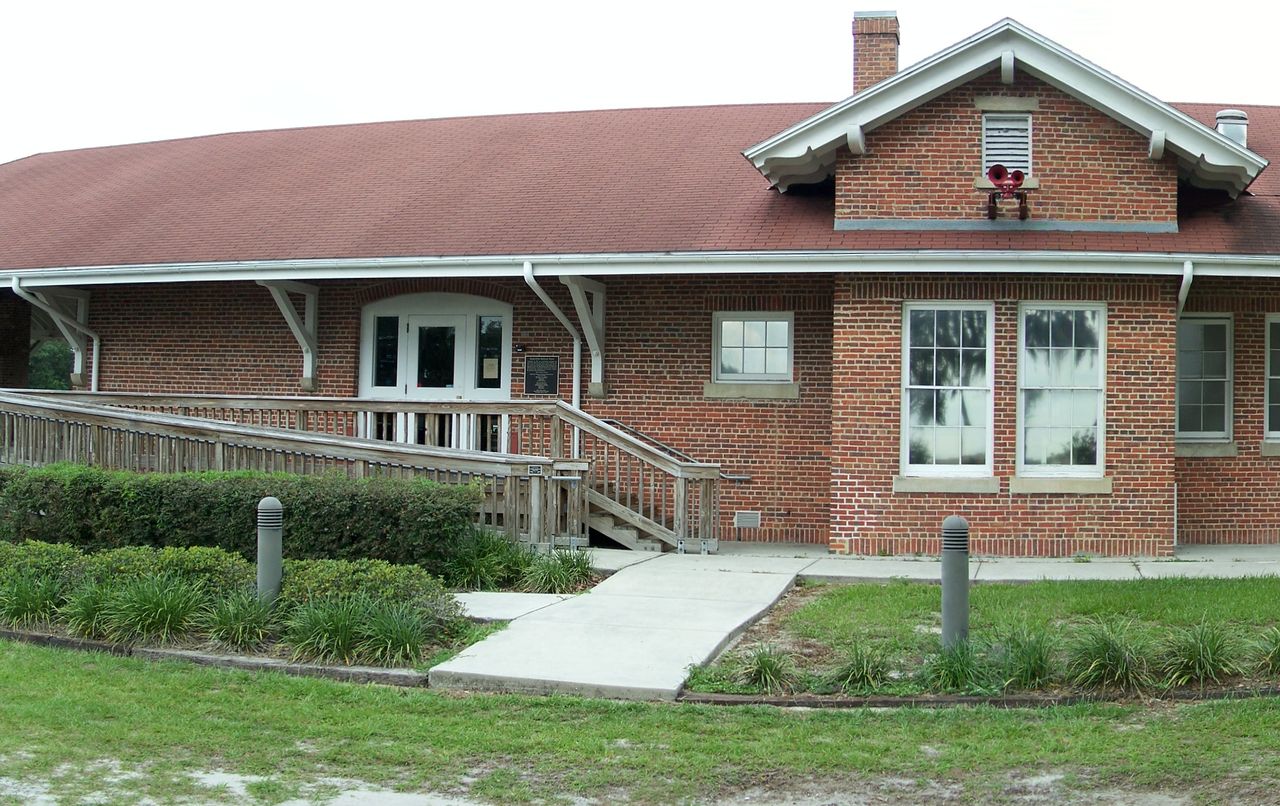 The long red-brick Zephyrhills depot, now a museum, with a hipped roof, white brackets and a ramp to its door